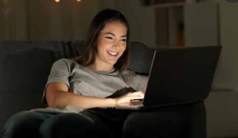 Woman smiling while using a laptop