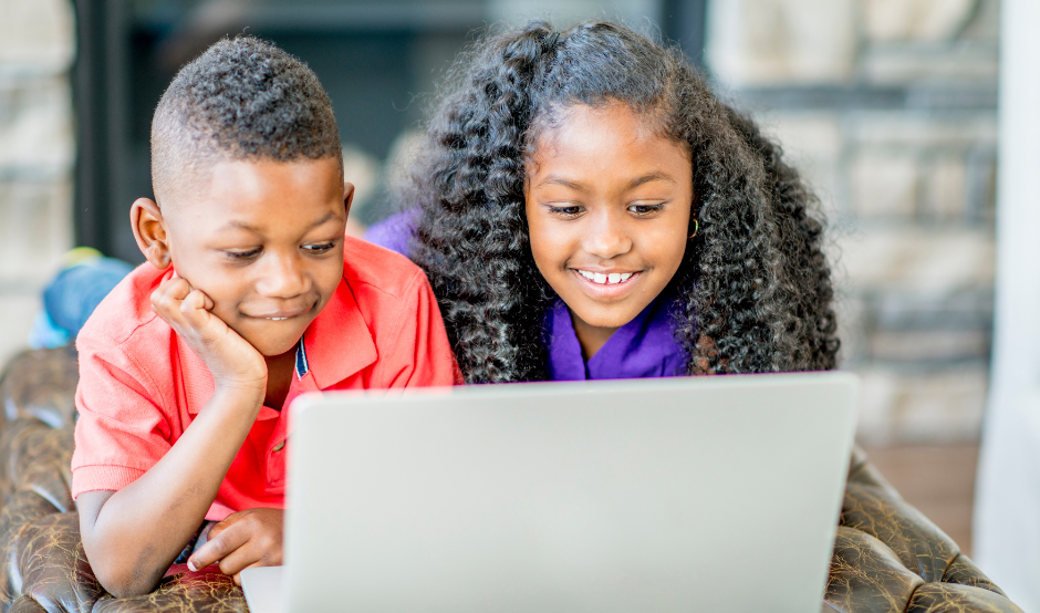 two children sat in front of a laptop