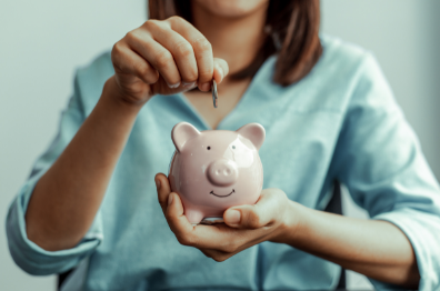 Lady putting a coin into a piggy bank