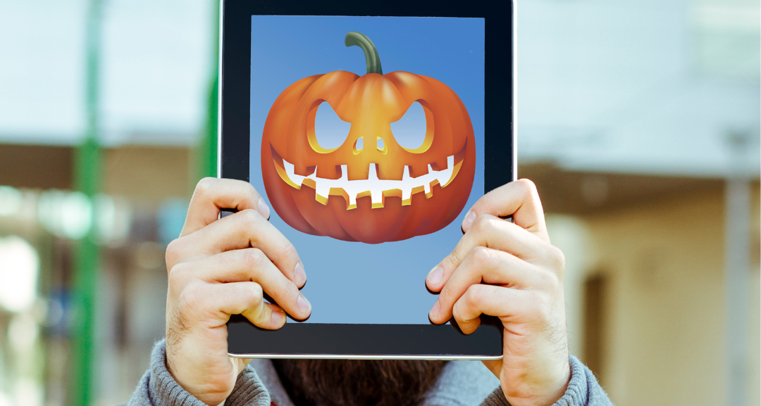 Man holding iPad with pumpkin on the screen